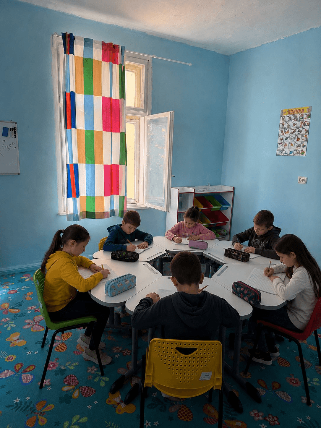 Деца пишат заедно в синята класна стая на Хралупата